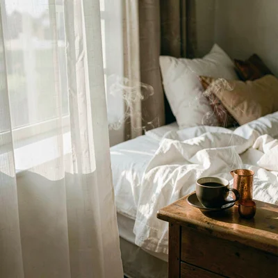 Intimate warm-toned photograph, Morning light through white gauze curtains onto 