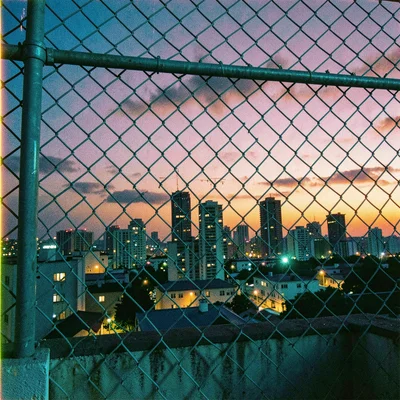 Cross-processed slide film photograph, City skyline at twilight through chain-li