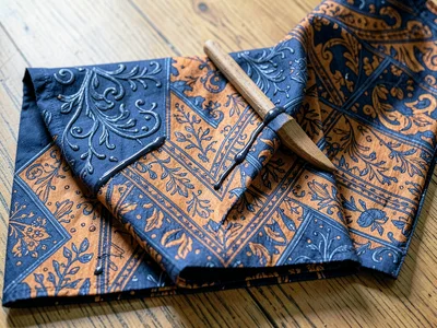 A completed batik cloth folded so the parang repeat creates a chevron at the fol