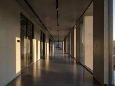 Long hallway in a modern office with polished concrete floors and indirect light