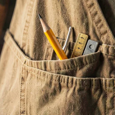 Close portrait of an apron pocket holding a sharpened pencil, a small ruler, and
