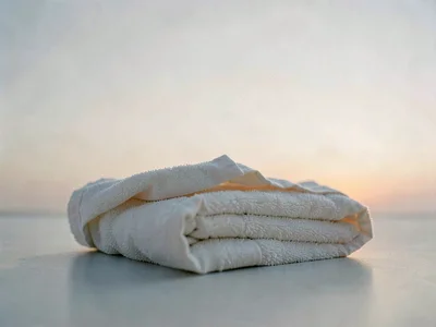 A folded towel viewed from very low angle, soft horizon glow behind, fabric edge