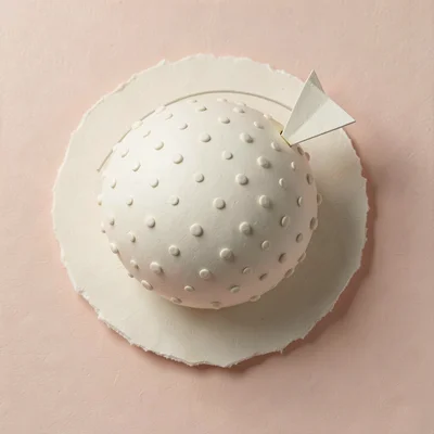 Round papercraft planet covered in tiny raised dots, orbited by a single small t