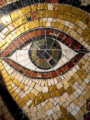 A mosaic portrait fragment — a single large eye rendered in tesserae, grout line