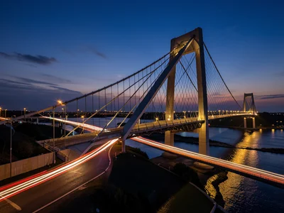 Modern suspension bridge at twilight with car light trails