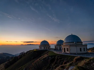 Multiple domes on hilltop against layered sunset