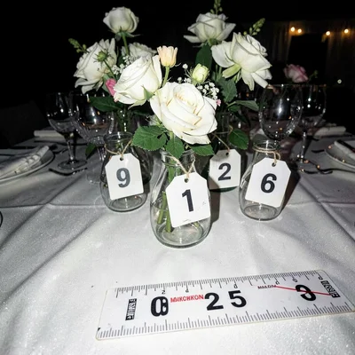 Wedding reception centerpieces with evidence tags and harsh flash