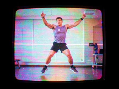 Frozen frame of VHS fitness video, instructor mid-jump with lower half displaced