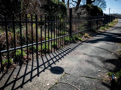 Shadow of fence on path
