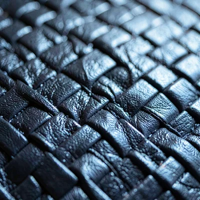 Macro of a leather bar-tape weave, slow oily sheen along the threads, hairline c