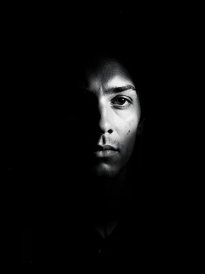 Half-face portrait emerging from shadow