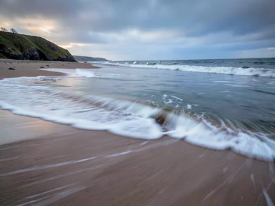Retreating wave leaving soft blur on sand