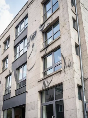 Building facade where windows form a face when viewed from specific angle