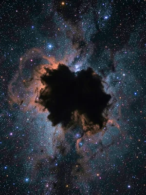 A dark nebula silhouetted against a bright emission nebula behind it — dense mol