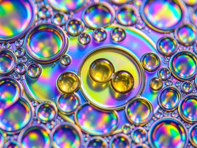 Oil drops of varying viscosity on water, thin sesame oil spreading wide vs thick