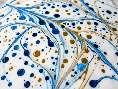 Traditional Turkish ebru stone pattern, random scattered drops of blue and gold 