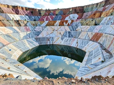 Water pool reflecting sky in quarry floor depression