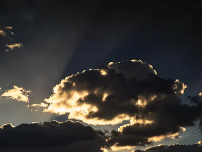 Cloud illuminated from below by setting sun against dark upper sky
