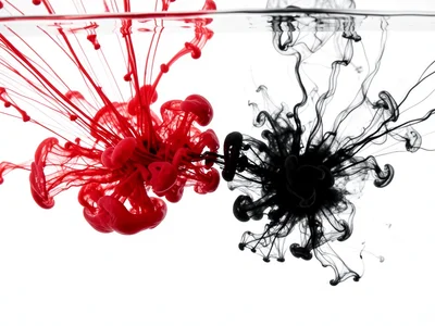 Red and black ink meeting underwater, red diffusing fast and thin, black staying