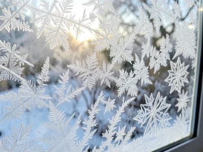 Hoar frost on the exterior of a window, seen from inside, creating a soft white 