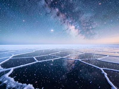 Starry night reflected in salt flat — sky full of stars above, identical star fi