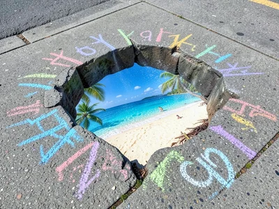 A 3D chalk illusion: a realistic hole in the sidewalk revealing a tropical beach