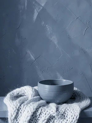 Slate blue study, ceramic bowl, wool blanket, painted wall, cool tonal control