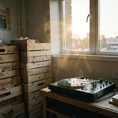 Atmospheric station corner at sunrise with a stack of vinyl crates and a turntab