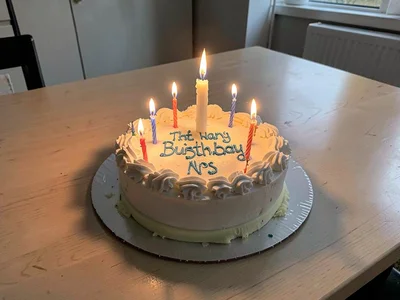 Child's birthday cake with unlit candles on empty table, single memorial candle 