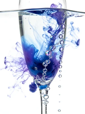 Close-up of champagne glass with ascending bubble chains, each bubble catching p