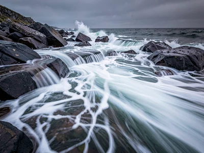 Crashing waves rendered silk-smooth over dark granite