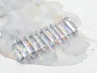 Refracted ice-clear lowpoly xylophone with a row of transparent bars catching cr