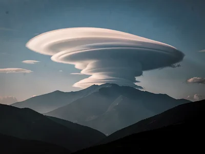 Single lenticular cloud forming over invisible mountain