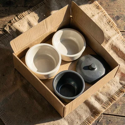 Tabletop overhead of an unboxed feeder with all parts (bowl, hopper, lid) on bur