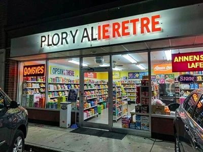 Store exterior at night, fluorescent glow through windows, open late, always the