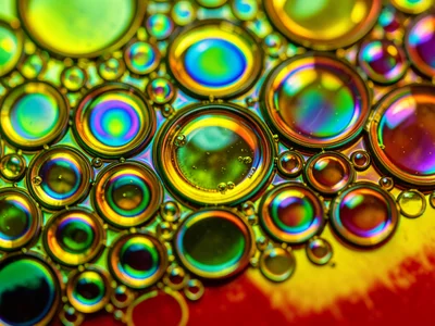 Olive oil on warm water with food coloring below, green tint visible through flo