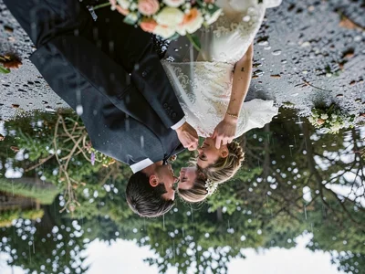 Puddle containing upside-down wedding couple, reality inverted in rainwater