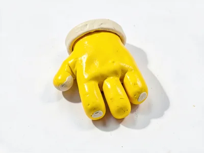Snug chunky clay glove in primary yellow with stubby cream-toned cuff and oversi