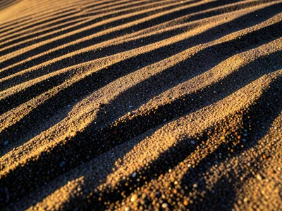 Sand with mineral sorting, heavy dark grains concentrated in streaks among light