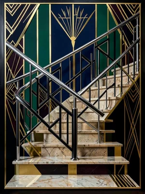 A staircase railing in chrome and black, geometric balusters creating a zigzag p