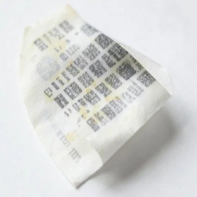 Receipt paper curl macro, coiled spring shape from thermal printing heat, showin