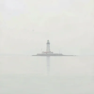 Caisson lighthouse far from any shore, the sea around it perfectly flat and pale