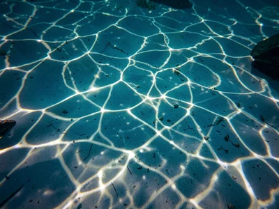 Soft caustic pattern filtered through deep clear water