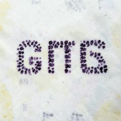 A close-up of thermal paper showing the characteristic purple-black dots that fo
