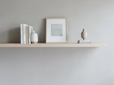Shelf styling: books, ceramic vase, framed print, small sculpture, balanced asym