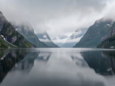 Perfect stillness on fjord surface reflecting gray